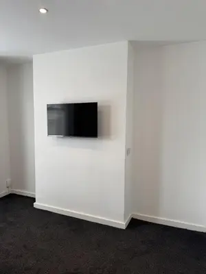 a white wall with a flat screen tv on a wall at Blackpool Abode - Suites by the Sea in Blackpool