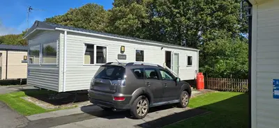a car parked in front of a tiny house at Lakeland leisure park sleeps up to 8 in Cark