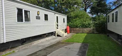 a white trailer is parked next to a yard at Lakeland leisure park sleeps up to 8 in Cark