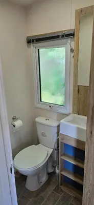 a small bathroom with a toilet and a window at Lakeland leisure park sleeps up to 8 in Cark