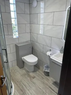 a white bathroom with a toilet and a sink at Ulverstons little gem - Sleeps 2 - Free Parking in Ulverston