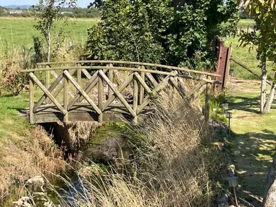 a wooden bridge over a creek in a field at Ulverstons little gem - Sleeps 2 - Free Parking in Ulverston