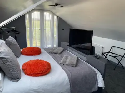a bedroom with a large bed with a flat screen tv at Ulverstons little gem - Sleeps 2 - Free Parking in Ulverston