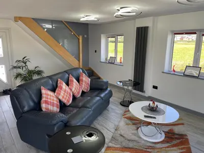 a living room with a leather couch and a table at Ulverstons little gem - Sleeps 2 - Free Parking in Ulverston
