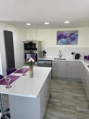 a kitchen with a white counter with two wine glasses at Ulverstons little gem - Sleeps 2 - Free Parking in Ulverston