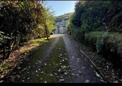 an empty road with a house on a hill at 4 Bed Retreat-Sleeps 7-Parking-Garden-Lake Views in Bolton