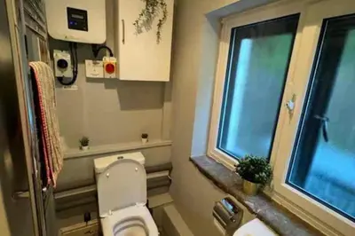 a small bathroom with a toilet and a window at 4 Bed Retreat-Sleeps 7-Parking-Garden-Lake Views in Bolton