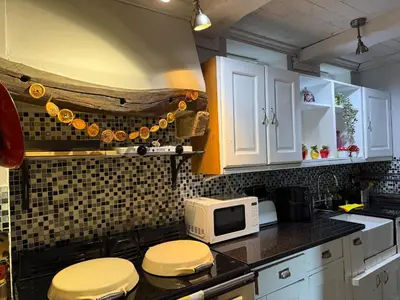a kitchen with white cabinets and a microwave at 4 Bed Retreat-Sleeps 7-Parking-Garden-Lake Views in Bolton