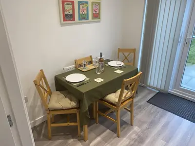 a dining room table with a green table cloth and chairs at Beach House Seaside Dunes in Lytham St Annes
