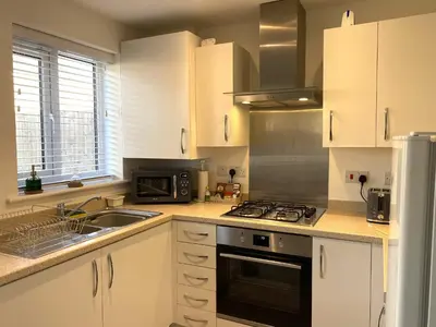 a kitchen with a sink and a stove top oven at Beach House Seaside Dunes in Lytham St Annes