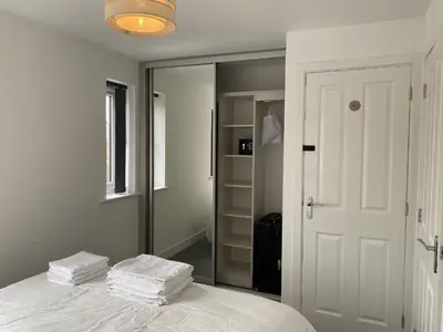 a bedroom with a bed with two stacks of towels at Beach House Seaside Dunes in Lytham St Annes