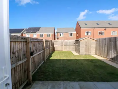 a backyard with a fence and some houses at Beach House Seaside Dunes in Lytham St Annes