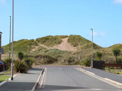 an empty road with a hill in the background at Beach House Seaside Dunes in Lytham St Annes