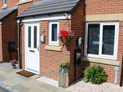 a brick house with a white door and a window at Beach House Seaside Dunes in Lytham St Annes