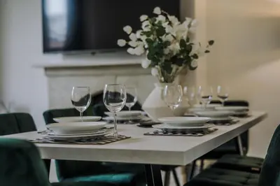 a table with glasses and plates and a vase of flowers at Onslow House - Air Host & Stay - 5 bed, Sleeps 14 in Liverpool