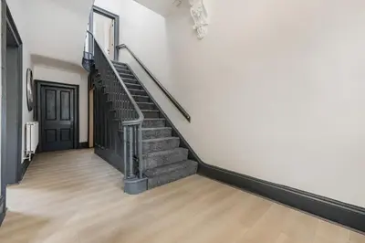 a staircase in a white room with wooden floors at Onslow House - Air Host & Stay - 5 bed, Sleeps 14 in Liverpool