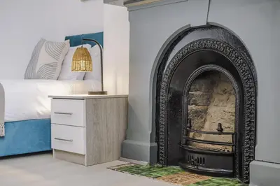 a bedroom with a fireplace next to a bed at Onslow House - Air Host & Stay - 5 bed, Sleeps 14 in Liverpool