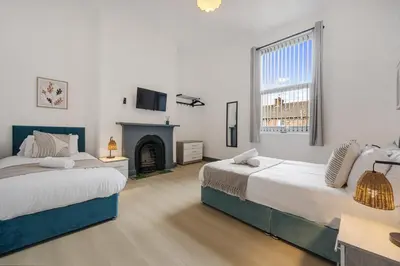a bedroom with two beds and a fireplace at Onslow House - Air Host & Stay - 5 bed, Sleeps 14 in Liverpool