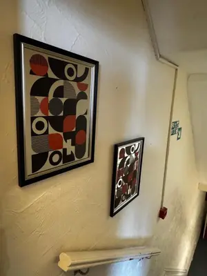 two framed pictures on a wall above a bench at Reads Avenue 1 Bed Apartment - Next To H&A Social Club - Minutes from Winter Gardens & Town Centre! in Blackpool