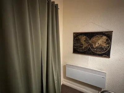 a room with a curtain and a picture on the wall at Reads Avenue 1 Bed Apartment - Next To H&A Social Club - Minutes from Winter Gardens & Town Centre! in Blackpool