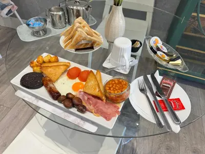 a glass table with a plate of food on it at Reads Avenue 1 Bed Apartment - Next To H&A Social Club - Minutes from Winter Gardens & Town Centre! in Blackpool