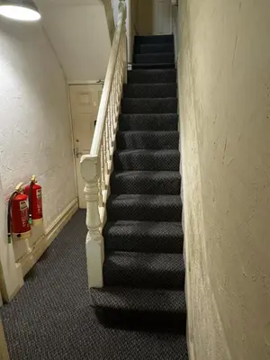 a staircase in a building with a fire extinguisher at Reads Avenue 1 Bed Apartment - Next To H&A Social Club - Minutes from Winter Gardens & Town Centre! in Blackpool