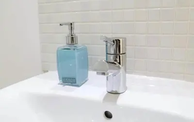 a soap dispenser sitting on top of a bathroom sink at Modern City Centre Apartment in Liverpool