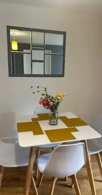 a dining room table with a vase of flowers on it at Modern City Centre Apartment in Liverpool