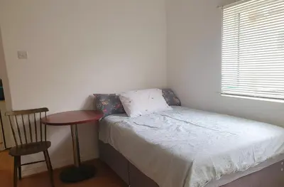 a small bedroom with a bed and a table and a chair at Holiday flat first floor in Blackpool