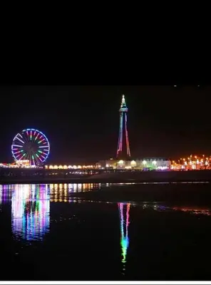 a lighthouse and a ferris wheel at night at Holiday flat first floor in Blackpool