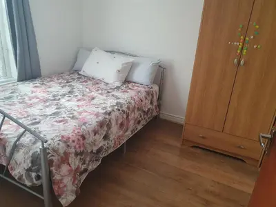 a small bedroom with a bed with a floral bedspread at Holiday flat first floor in Blackpool