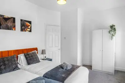 a bedroom with a bed and a dresser in it at Modern 2-Bedroom Contractor House with 4 Beds, Free Parking, High-Speed Wi-Fi in Seacombe
