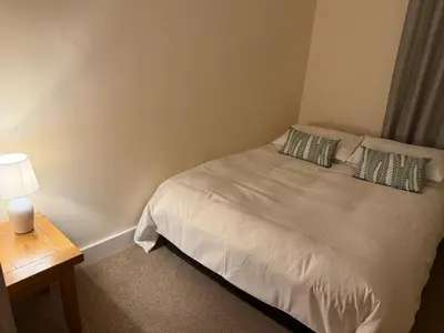 a bed with two pillows and a lamp on a table at 2-Bedroom Flat Near River Lune in Halton