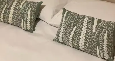 two pillows sitting on top of a bed at 2-Bedroom Flat Near River Lune in Halton