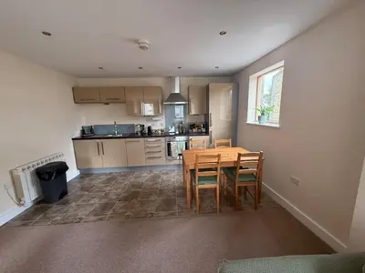 a kitchen and dining room with a table and chairs at 2-Bedroom Flat Near River Lune in Halton