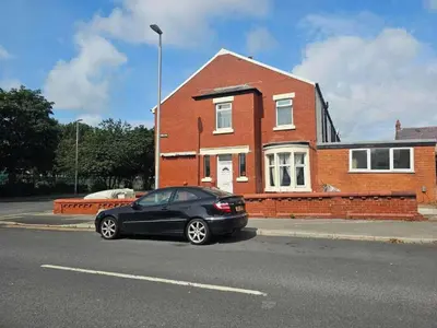 a black car parked in front of a brick house at Modern Seaside Stay at Bela Grove-Sleeps8 in Blackpool