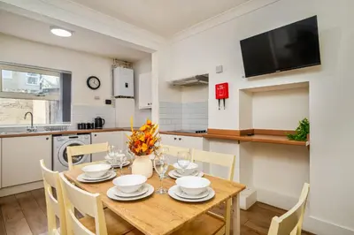 a dining room with a wooden table and chairs at Birkenhead Haven - Sleeps 14 - Family and Group Stay in Birkenhead