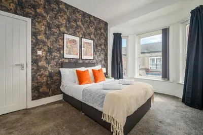 a bedroom with a large bed with orange pillows at Birkenhead Haven - Sleeps 14 - Family and Group Stay in Birkenhead
