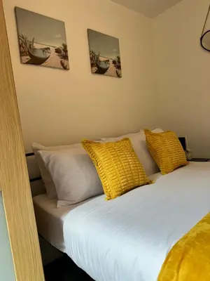 a bedroom with a bed with yellow pillows at 2 Bedroom City Centre Apartment Free Secure Parking in Liverpool