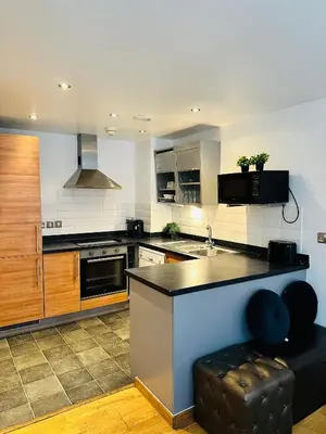 a large kitchen with a counter and a stove at 2 Bedroom City Centre Apartment Free Secure Parking in Liverpool