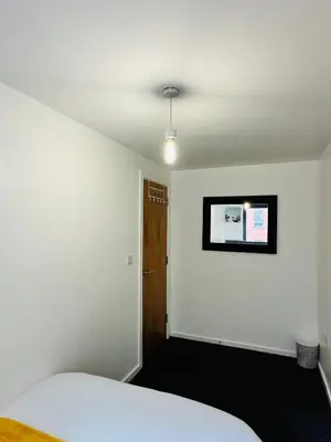 a bedroom with a white bed and a black floor at 2 Bedroom City Centre Apartment Free Secure Parking in Liverpool