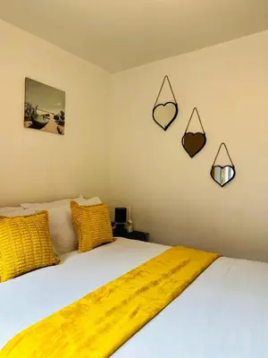 a bedroom with a bed with a yellow blanket on it at 2 Bedroom City Centre Apartment Free Secure Parking in Liverpool