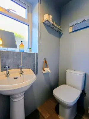 a bathroom with a sink and a toilet and a window at Rosemount Guest Suite in Grange Over Sands