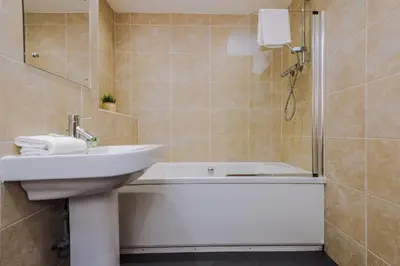 a bathroom with a tub and a sink and a shower at Spacious City Centre 2 Beds 2 baths Sleeps 10 in Liverpool