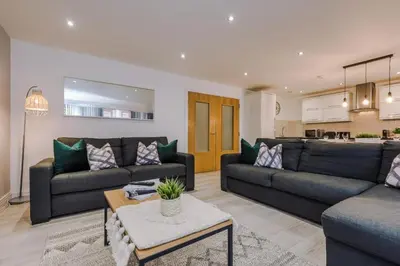 a living room with two couches and a kitchen at Spacious City Centre 2 Beds 2 baths Sleeps 10 in Liverpool