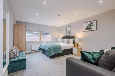 a bedroom with a bed and a couch at Spacious City Centre 2 Beds 2 baths Sleeps 10 in Liverpool