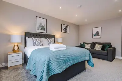 a bedroom with a large bed and a couch at Spacious City Centre 2 Beds 2 baths Sleeps 10 in Liverpool