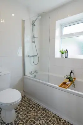 a white bathroom with a shower and a toilet at Quiet St Helens Home Near Train Station, Free Parking and WiFi in Saint Helens