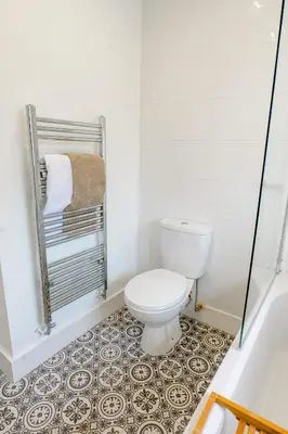 a bathroom with a toilet and a tile floor at Quiet St Helens Home Near Train Station, Free Parking and WiFi in Saint Helens