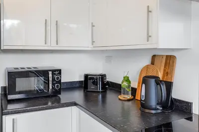 a kitchen counter with a microwave and a toaster oven at Quiet St Helens Home Near Train Station, Free Parking and WiFi in Saint Helens